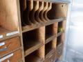 Wooden storage unit with multiple compartments and shelves designed for organizing tools and supplies inside a vehicle.