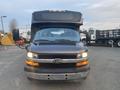 A 2017 Chevrolet Express van with a black front and a raised roof featuring dual side mirrors and a prominent Chevrolet emblem