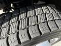 Close-up of a heavily worn tire tread on a 2018 Ford F-550 showing deep grooves and cracks indicating significant use and wear