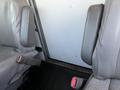 Interior view of a 2009 GMC Savana showing two gray seats with seatbelts and armrests