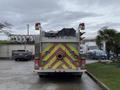 A rear view of a 2001 Freightliner FL80 fire truck with emergency lights and reflective striping on the body