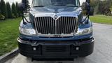 Front view of a blue 2009 International 4300 truck showcasing a large chrome grille and prominent headlights with side mirrors extending outward