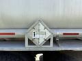 A metal placard with a diamond shape and chains attached to it mounted on the rear of a 2009 International 7500 truck