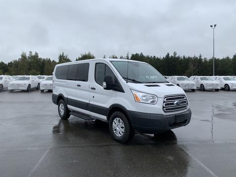 A 2017 Ford Transit van in white with chrome accents and alloy wheels parked in a lot