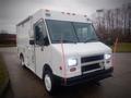 A white 2003 Freightliner MT45 Chassis vehicle with a boxy design and multiple lights on the front grille