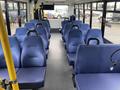 Interior of a 2017 Chevrolet Express with blue upholstered seats arranged in rows facing forward and spaces in between