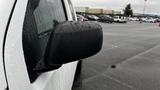 A 2016 Nissan Frontier with a side mirror covered in raindrops