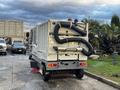A 2007 Tennant Sentinel outdoor floor scrubber with a large front water tank and hoses attached on the back for suction and cleaning
