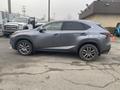 A 2021 Lexus NX 300 parked on a gravel surface with a gray exterior and alloy wheels