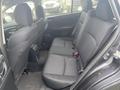 2014 Subaru Impreza interior view showcasing the back seat with black fabric upholstery and seat belts