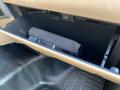 A 2013 Ford F-450 SD glove compartment with a black rolled-up cloth inside