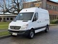 A 2012 Mercedes-Benz Sprinter van in white with a black lower section and Mercedes-Benz emblem on the front grille