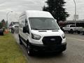 A white 2021 Ford Transit van with a black grille parked on the side of the road