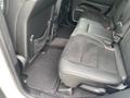 Interior view of the back seat of a 2018 Jeep Grand Cherokee featuring black leather and suede upholstery with a storage net on the rear of the front seat