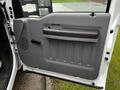 A gray door panel from a 2011 Ford F-250 SD featuring a handle and textured design elements