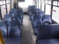 Interior of a 2016 Chevrolet Express with blue upholstered seats arranged in rows and a clear aisle in the center