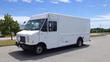 A white 2011 Ford Econoline truck with a boxy design and a single front door parked on a lot