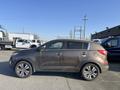 A 2012 Kia Sportage in a brown color with a dirty exterior and silver alloy wheels viewed from the side
