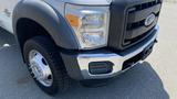 A 2011 Ford F-450 SD with a chrome front bumper and black grille showing the right front corner and wheel