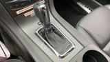 A close-up of the gear shifter in a 2013 Lincoln MKT featuring a leather boot and chrome accents with the gear selection labeled P R N D L