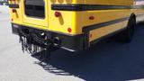 A 2014 International 3000 yellow school bus with a rear view featuring a black bumper and chains hanging down from the back