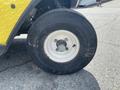 Close-up of a tire on a yellow 1999 Ez-go Industrial vehicle showing the wheel rim and tread detail