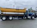 A 2016 International 7400 truck with a yellow dump body attached to its flatbed and a black plow at the front