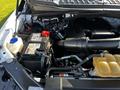 A 2017 Ford F-150 engine compartment showing the battery and various components including hoses and a coolant reservoir
