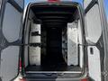 Interior view of a 2021 Mercedes-Benz Sprinter van with metallic shelving units installed on both sides of the cargo space