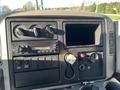 Dashboard of a 2013 International 4300 featuring climate controls a digital clock radio and various controls and gauges