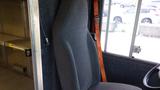 A gray fabric driver's seat in a 2011 Ford Econoline van with a simple design and a wooden armrest