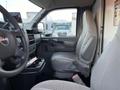 Interior view of a 2009 GMC Savana showing the driver's seat and dashboard with gray upholstery and an empty cup holder