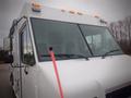 A white 2003 Freightliner MT45 Chassis with multiple orange lights on the roof and a large windshield