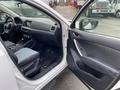 An interior view of a 2016 Mazda CX-5 showing the driver's seat dashboard and door panel with controls and surfaces in grey and black colors