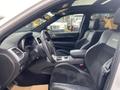 Interior view of a 2018 Jeep Grand Cherokee showcasing the driver's seat dashboard and steering wheel with sporty accent details and leather upholstery