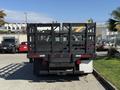 A black 2016 Ford F-350 SD truck with a flatbed and protective railing at the rear