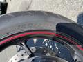 Close-up of a motorcycle tire with a prominent size marking of 120/70 and a distinct red stripe along the edge