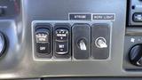 Dashboard controls of a 2006 Ford F-650 featuring buttons for cruise control strobe and work light switches