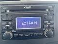 A Jensen car radio display showing the time 2:14 AM with various control buttons and settings below the screen