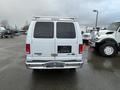 A white 2014 Ford Econoline van viewed from the rear with a tailgate and minimal markings on the surface