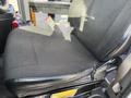 A black cloth driver's seat of a 2018 Chevrolet Express showing a simple and functional design without any visible adjustments or features