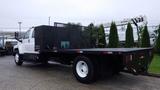 A 2008 Chevrolet C7500 flatbed truck with a black cargo box and mesh sides, featuring dual rear wheels and white rims