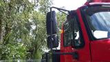 A red 2010 International 4400 truck with a large side mirror mounted on the driver's side