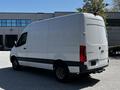 A 2022 Mercedes-Benz Sprinter van with a sleek white exterior and a high roof, featuring a smooth rear design and large cargo area