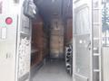 Interior view of a 2007 Morgan Olson Workhorse W42 featuring metal shelving wood paneling and pipes along the side