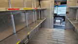 2006 Ford Econoline interior with empty metal shelves and a view into the driver's area