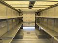 Interior of a 2012 Ford Econoline cargo van featuring metal shelving on both sides and a spacious empty cargo area