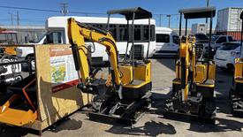 A yellow and black 2021 Cael-1T Mini excavator with a bucket attachment positioned alongside another similar machine