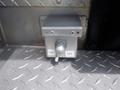 A metal switch box with an on-off lever mounted on a patterned metal surface with visible screws and a keyhole