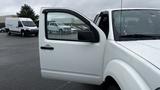 A white 2016 Nissan Frontier pickup truck with an open driver side door